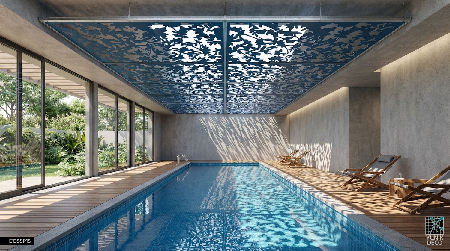 Piscine intérieure sublimée par un puit de lumière au motif FRONDAISON, créant une atmosphère lumineuse naturelle, design par Yunik Déco